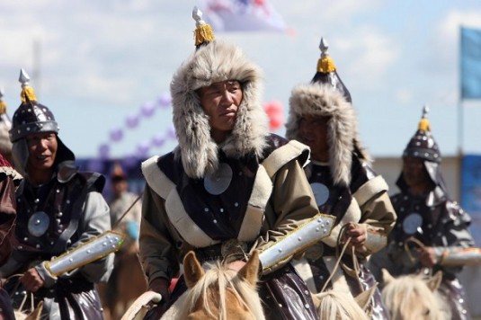 Mongolian horsemen ride in formation during opening ceremony of annual Naadam festival in Arvaikheer