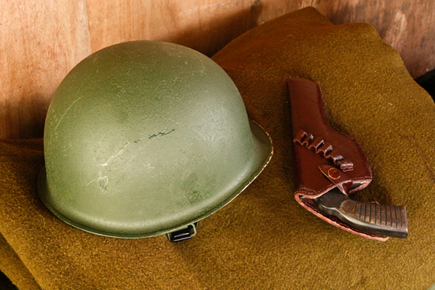 Military helmet and revolver on blanket