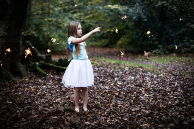 Young Girl in the Forest Pointing at Fairy Sparkles