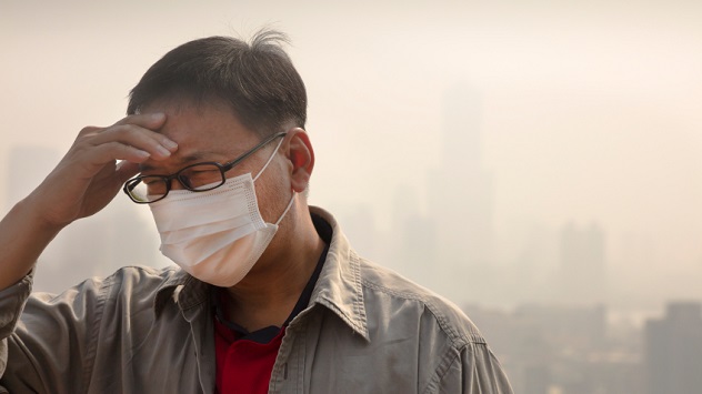 Asian man wearing mouth mask against air pollution