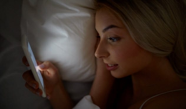1a-woman-using-smartphone-in-bed-540102896