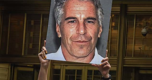 Protestor holding Jeffrey Epstein poster