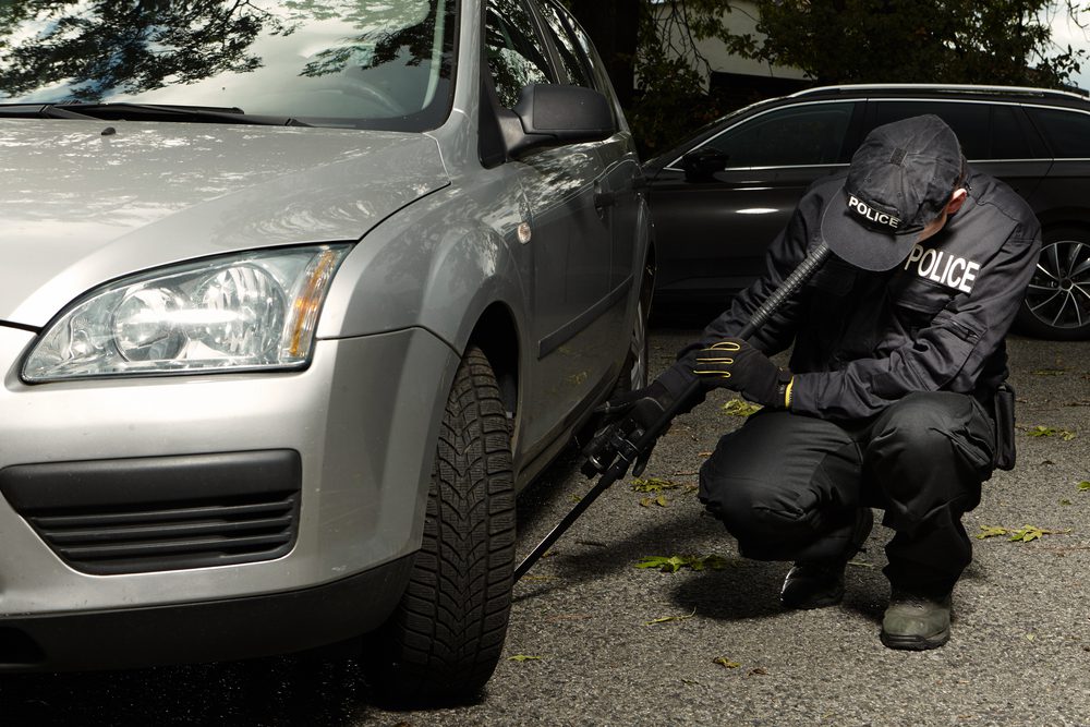 Shadowy figure under a car, representing an unseen threat